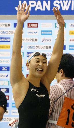 女子５０メートル平泳ぎで優勝し、笑顔で声援に応える鈴木聡美