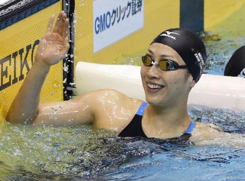 女子１００メートル背泳ぎで優勝し、笑顔で手を振る寺川綾