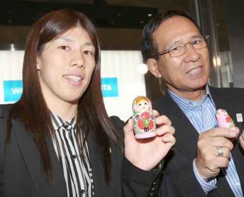 ロシアへ出発する吉田（左）と福田富昭会長はマトリョーシカ人形を手に笑顔