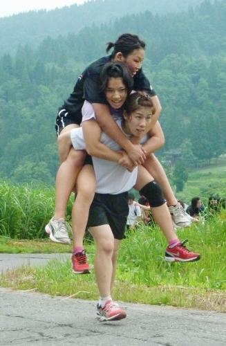 レスリング女子の公開練習で選手２人を背負って坂道を上る吉田沙保里
