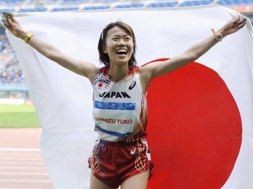 女子１万メートルで優勝し、日の丸を掲げる清水裕子