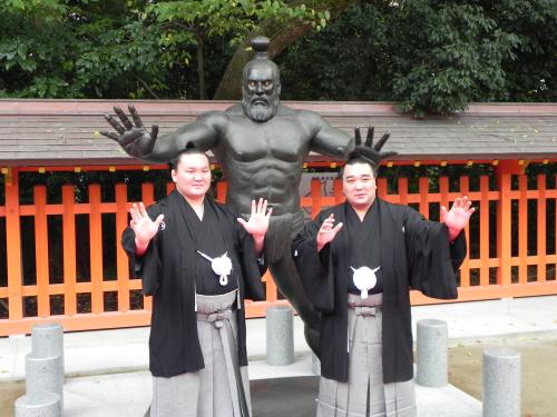 住吉神社の境内に立てられた古代力士像の前でポーズする白鵬（左）と日馬富士