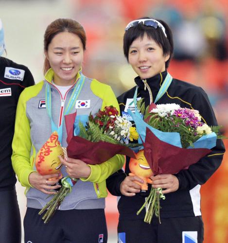 女子５００メートルで３位となり表彰台で笑顔の小平奈緒（右）と優勝した李相花