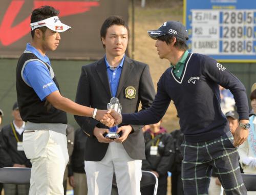 表彰式で優勝した松山英樹（左）と握手を交わす石川遼