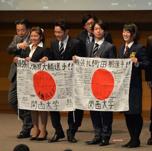 寄せ書きの入った国旗を手に、記念写真におさまる高橋大輔（左から３人目）と町田樹（同５人目）