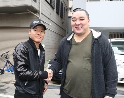 朝稽古に訪れた亀田和毅（左）と握手する日馬富士