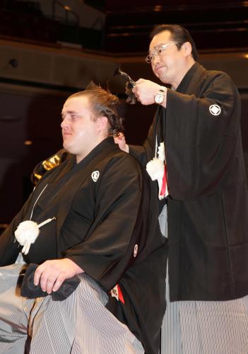 断髪式で把瑠都（左）のマゲに止めばさみを入れる師匠の尾上親方