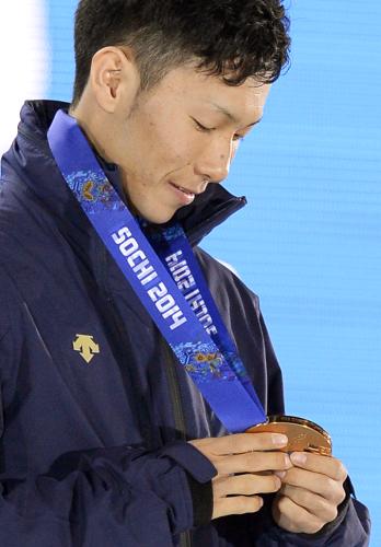 スノーボード男子ハーフパイプで獲得した銅メダルを見つめる平岡卓