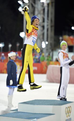 ジャンプ男子ラージヒルで銀メダルを獲得し、表彰台で跳び上がって喜ぶ葛西紀明