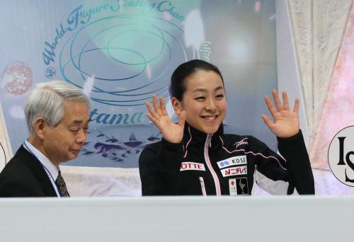 ＜フィギュア世界選手権女子ＳＰ＞キスアンドクライで手を振る浅田真央。左は佐藤コーチ