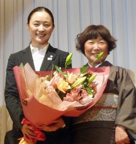所属先のシーズン報告会で、母圭子さん（右）から花束を受け取る上村愛子さん