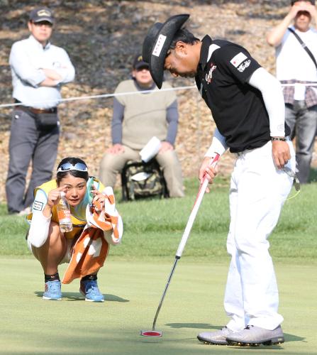 片山晋呉は７番グリーンでキャディーを務める女子プロゴルファー・山村彩恵（左）ともにパットラインをよむ