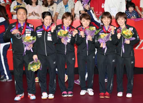 ＜世界卓球＞表彰台で喜ぶ（左から）村上監督、森、田代、石垣、平野、石川