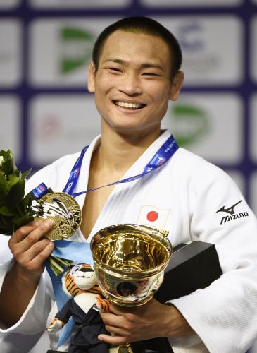 柔道の世界選手権男子66キロ級で３連覇を達成し、笑顔で金メダルを掲げる海老沼匡