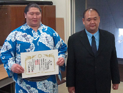 相撲教習所卒業証書を受け取り、師匠の湊親方と記念撮影する逸ノ城（左）
