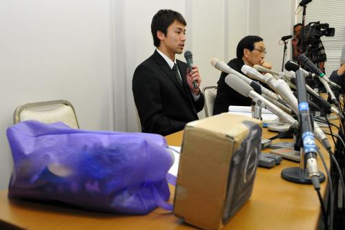 盗難問題となったバッグとカメラの模型を置き、会見する冨田（左）と国田弁護士