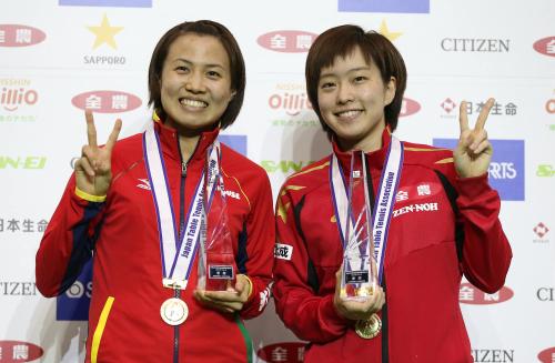 女子ダブルスで２年連続優勝を果たし、笑顔でＶサインする平野（左）と石川
