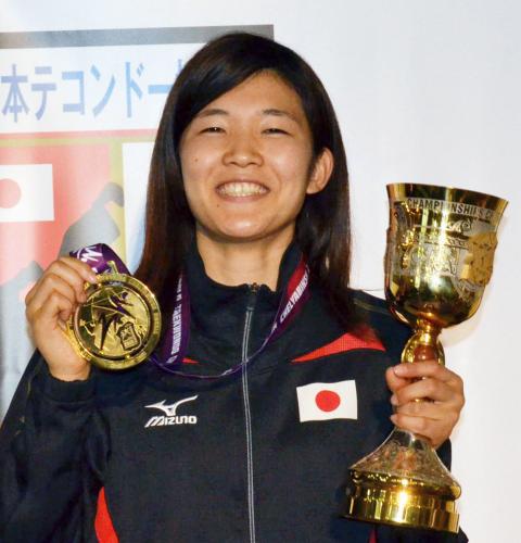 獲得した金メダルとトロフィーを手に笑顔を見せる浜田