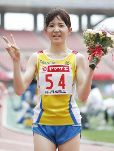 女子１万メートルで優勝し、花束を手に笑顔の西原加純