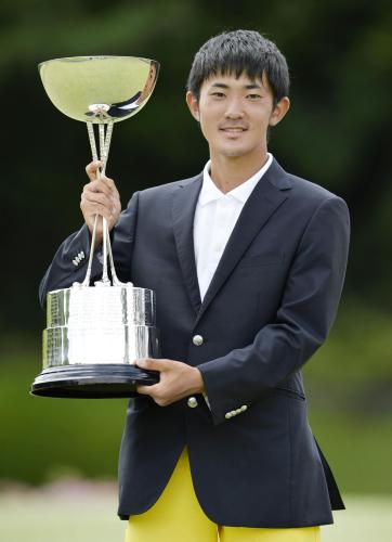 日本アマチュアゴルフ選手権で最年少優勝を果たしカップを手に笑顔の金谷