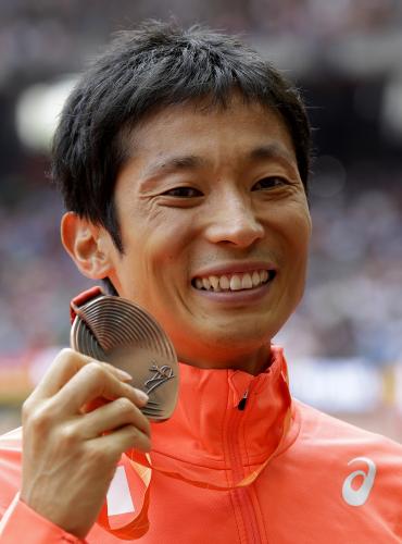 男子50キロ競歩で３位となり、表彰式で銅メダルを手にする谷井孝行（ＡＰ）