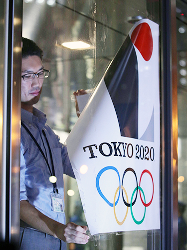 都庁に貼られた東京五輪エンブレムのポスターが職員の手ではがされる