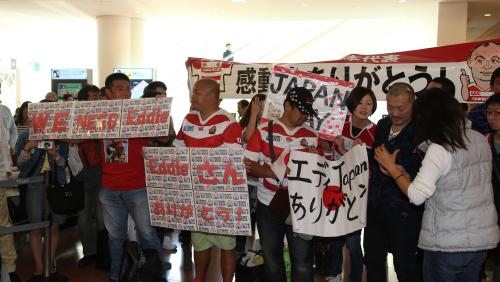 プラカードや横断幕を掲げて日本代表の到着を待つファン