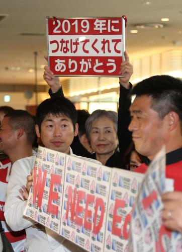 ボードを掲げて日本代表の到着を待つファン