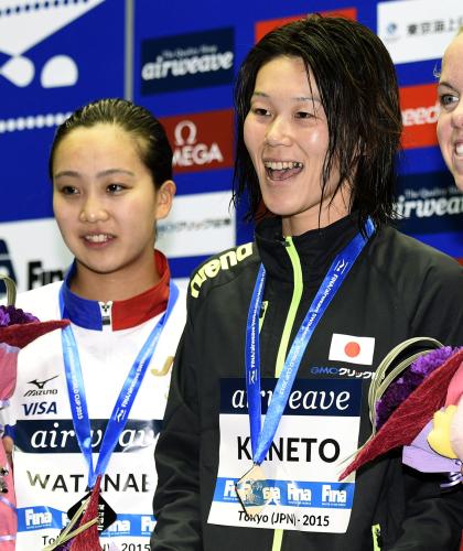女子２００メートル平泳ぎで優勝し、表彰式で笑顔の金藤理絵。左は２位の渡部香生子