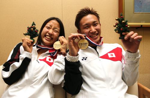 ワールドスーパーシリーズファイナルの金メダルとクリスマスツリーを手に笑顔の奥原（左）と桃田