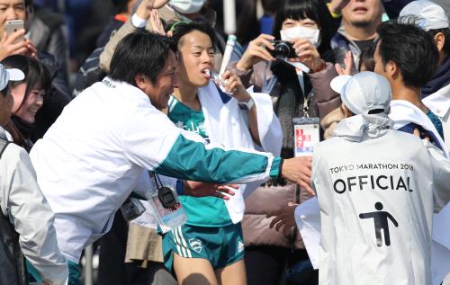 ＜東京マラソン＞ゴールした一色（右）と下田（中央）を出迎える青学大・原監督