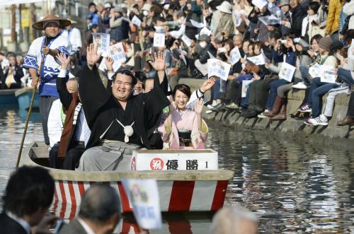 大相撲初場所で優勝し、手を振りながら水上パレードする大関琴奨菊関と祐未夫人