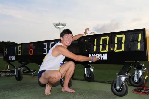 準決勝の記録、１０秒０１を示す時計の前で笑顔を見せる桐生