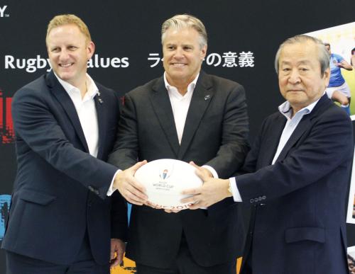 ワールドラグビーのブレット・ゴスパーＣＥＯ（中央）とポーズをとる日本大会組織委の嶋津昭事務総長（右）ら
