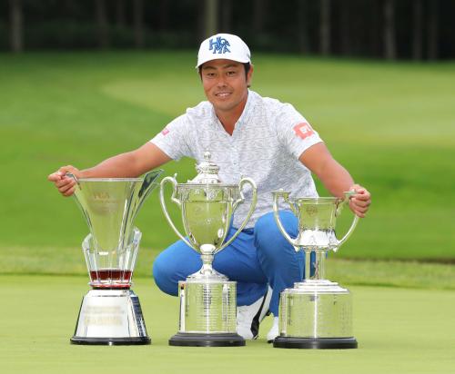 （左から）日清カップヌードル杯、日本プロゴルフ選手権大会優勝杯、文部科学大臣杯を前に笑顔の谷原秀人