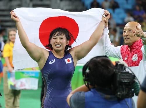 リオ五輪＜女子レスリング６９キロ決勝＞金メダルの土性は日の丸を掲げる（右は栄監督）