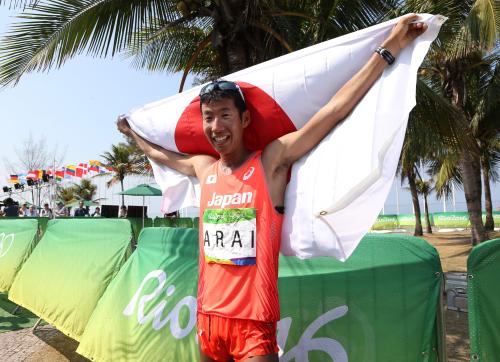 ＜男子５０キロ競歩＞銅メダルを獲得し、日の丸を背に笑顔の荒井