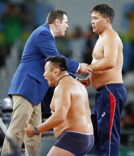 レスリング男子フリー65キロ級３位決定戦で、服を脱いで判定に抗議するモンゴル選手のコーチら
