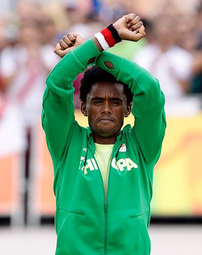 男子マラソンで銀メダルを獲得したエチオピアのフェイサ・リレサ。表彰式でも抗議のポーズ（ＡＰ）