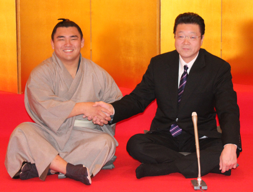 新十両昇進が決まり、笑顔で伊勢ケ浜親方（右）と握手する大相撲の照強
