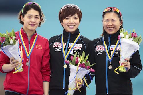 女子５００メートルで優勝し表彰台で笑顔を見せる小平奈緒（中央）、３位の辻麻希（右）