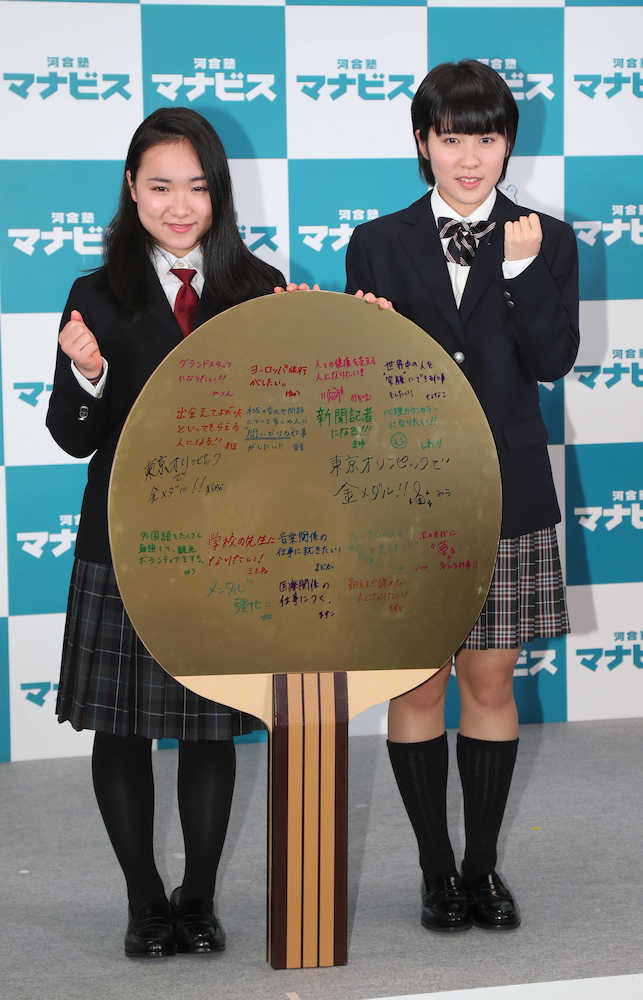今後の目標を書いた巨大なラケットを前に笑顔の伊藤美誠（左）と平野美宇