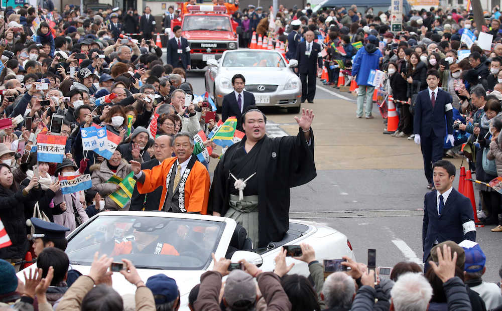 ＜稀勢の里・牛久祝賀パレード＞沿道のファンの祝福に、パレードカーから手を振り応える稀勢の里。左は根本洋治・牛久市長