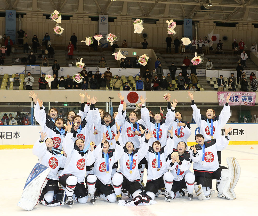 冬季アジア大会女子アイスホッケー決勝で中国を破り、金メダルを獲得したスマイルジャパンのメンバーは花束を投げて喜ぶ