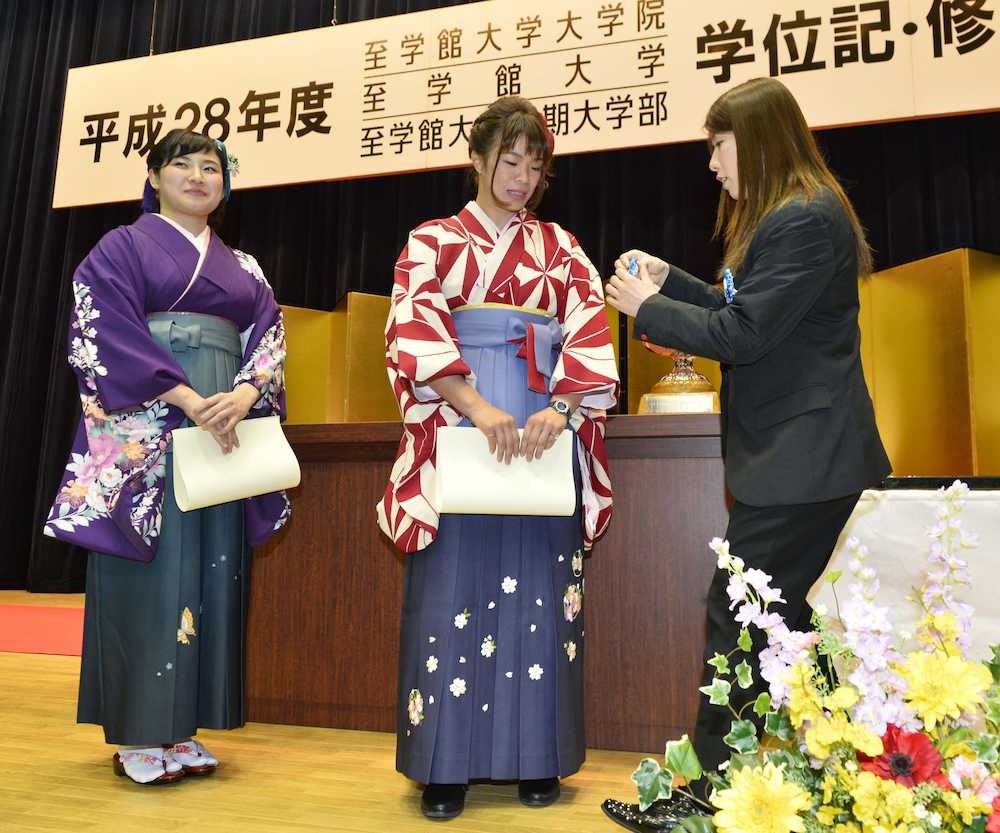 至学館大の学位記授与式で、副学長の吉田沙保里（右）から「吉田賞」を授与された川井梨紗子（中央）と土性沙羅