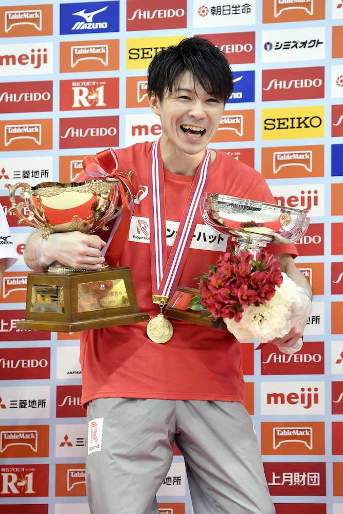 体操の全日本選手権男子個人総合で１０連覇を果たし、トロフィーを手に笑顔の内村航平
