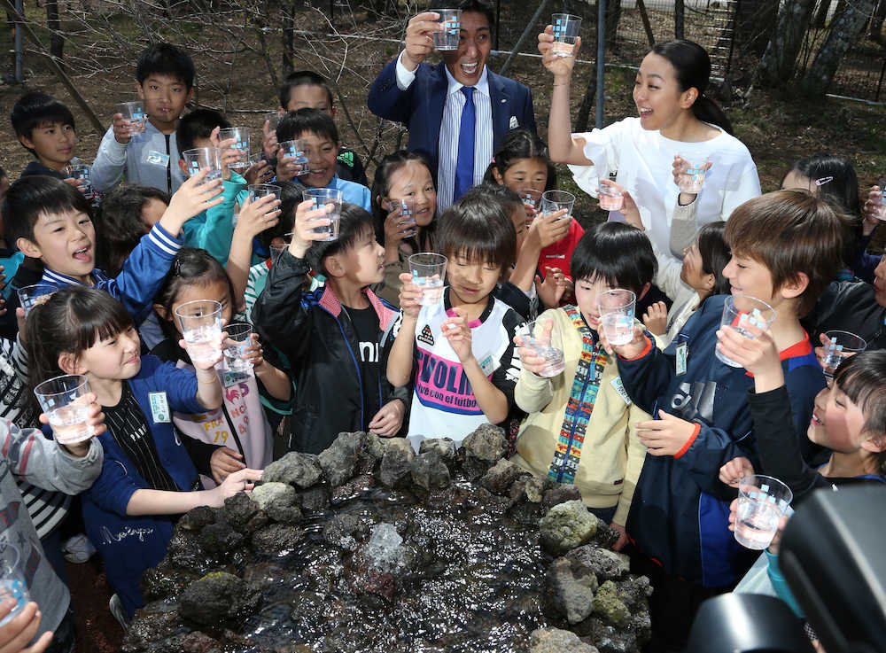 キララ富士山工場の敷地内にある源泉の近くで水をこどもたちと一緒に飲む浅田真央さん