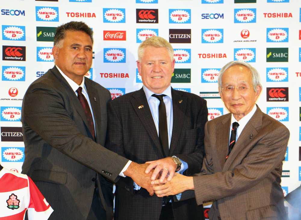 記者会見で手を合わせる（左から）ジェイミー・ジョセフ日本代表ヘッドコーチ、ニュージーランド・ラグビー協会のスティーブ・チューＣＥＯ、日本ラグビー協会の岡村正会長