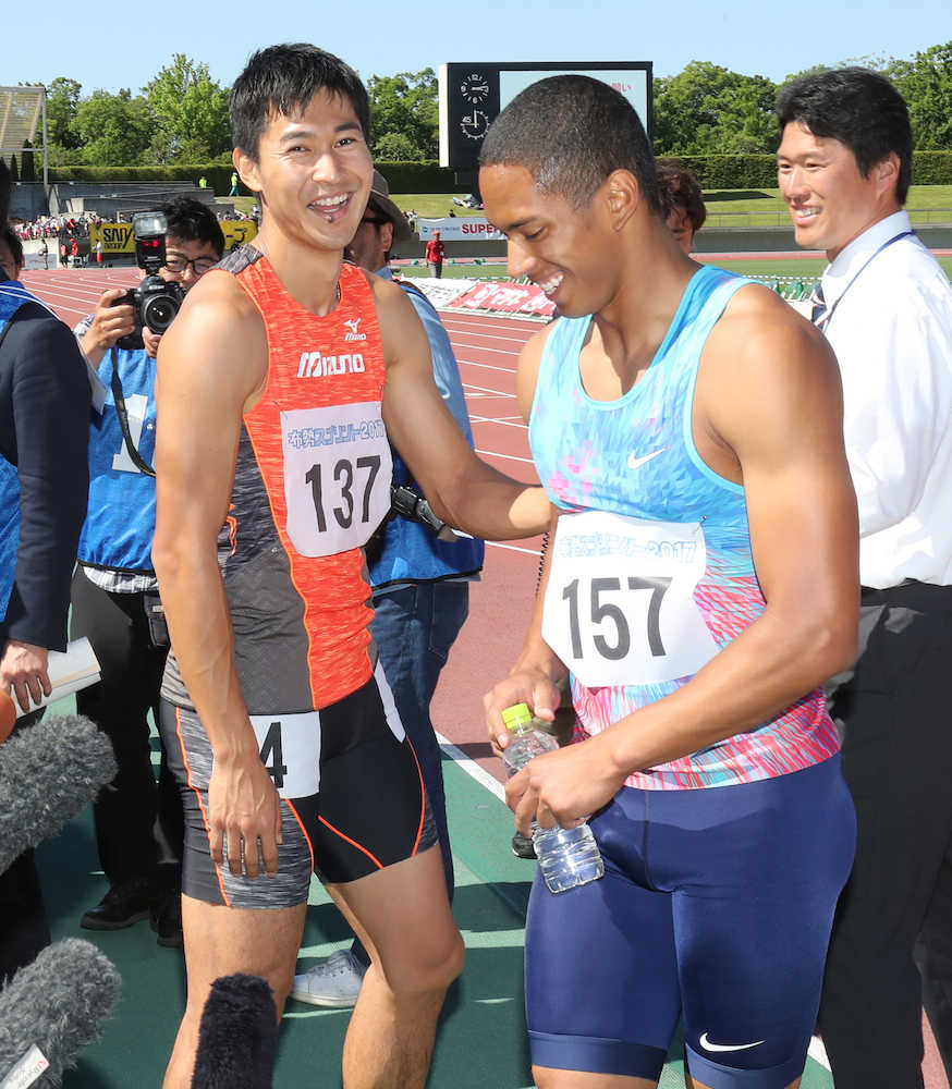 布勢スプリント男子１００メートル決勝のレース後、ケンブリッジ飛鳥（右）と健闘を称え合う飯塚翔太