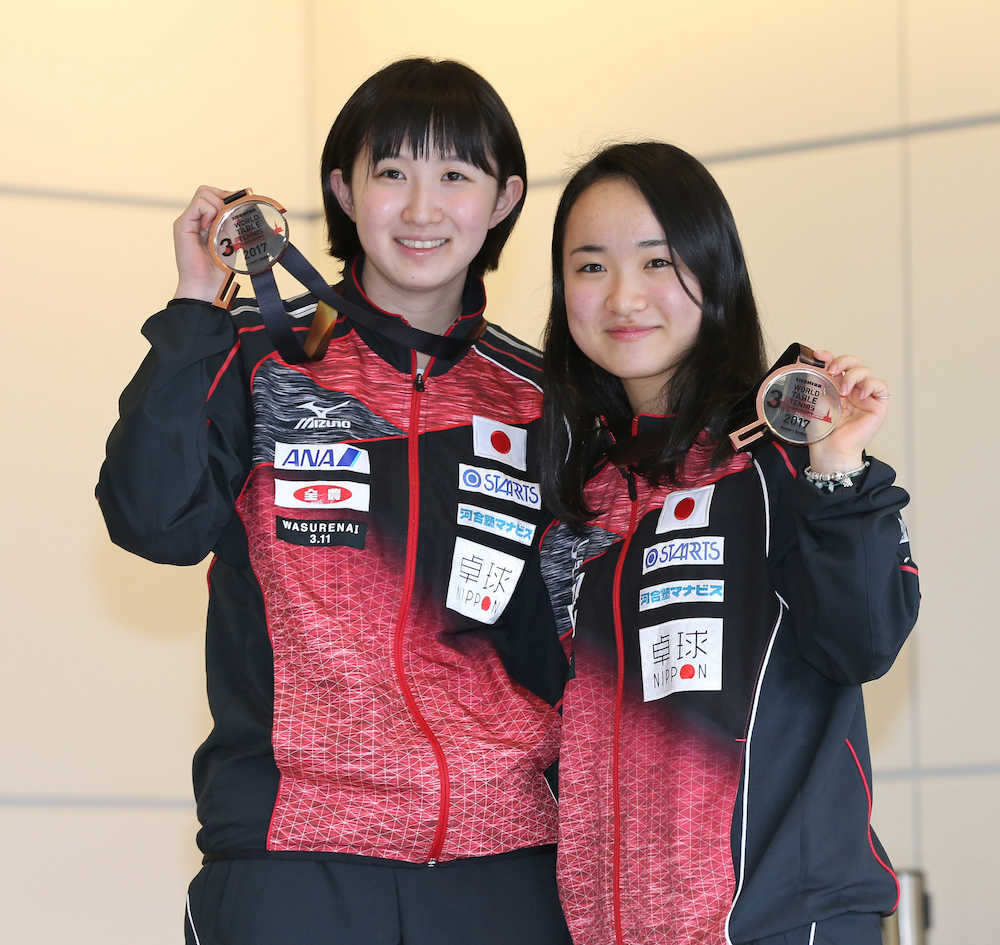 世界選手権から帰国し、メダルを披露する早田（左）と伊藤